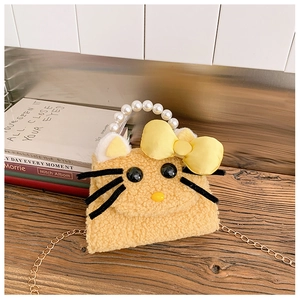 Detail of yellow plush cat bag featuring pearl handle and soft faux fur texture