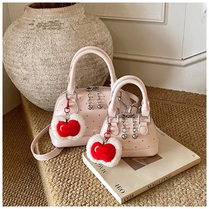 Detailed set of pink polka dot shell bags with plush apple charm and silver hardware