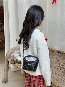 Vue détaillée d'un enfant portant un sac à bandoulière matelassé noir à chaîne dorée