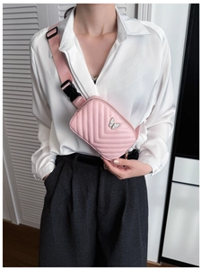 Close-up of pink quilted crossbody bag for kids with silver butterfly metal ornament