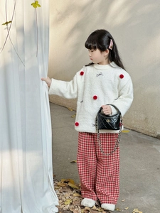 Détail du pantalon large à carreaux rouges et blancs avec haut d'automne en polaire douce