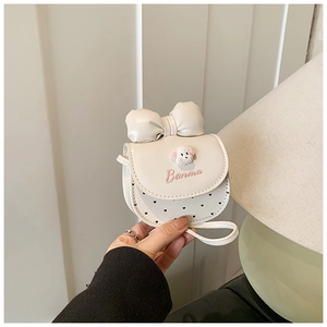 Détail d'un mini sac blanc orné d'un grand nœud, d'un patch chiot et de pois mignons