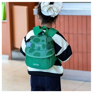 Detail of green turtle shell backpack with mesh padding worn by a child in-store
