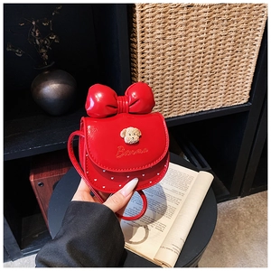 Détail d'un mini sac bandoulière rouge avec décor d'ours en peluche et pois
