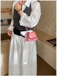 Détail du sac seau matelassé rose avec chaîne dorée et bandoulière assortie