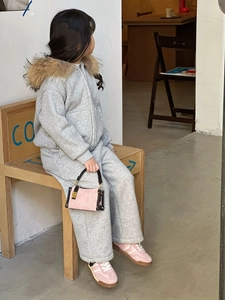 Detailansicht der gesteppten Handtasche und des grauen Kapuzenpullovers für Kinder