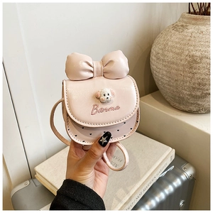 Détail du mini sac à bandoulière rose avec chiot en peluche et décoration de nœud