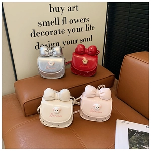 Détail de quatre mini sacs à nœuds colorés pour enfants sur un banc en cuir brun