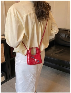 Détail du mini sac bandoulière matelassé rouge avec un écusson de cheval mignon pour femme