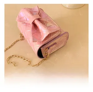 Close-up of the golden metal hooks and pearlized leather texture on the pink bow bag