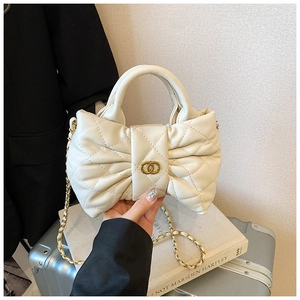 Detail of cream quilted leather bow bag with gold chain and interlocking logo
