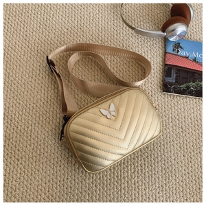 Detail of champagne gold kids fanny pack with V-quilt pattern and butterfly buckle