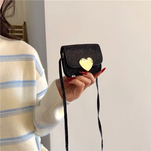 Gros plan du mini sac noir pailleté avec boucle coeur dorée et bandoulière fine