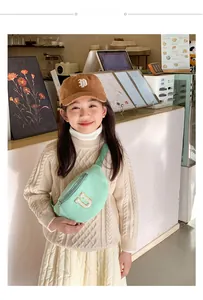 Sac de poitrine pour enfants en nylon vert menthe avec lettre U brodée sur un petit mannequin