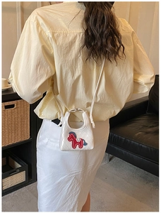 Vue arrière du mannequin portant un mini sac en cuir PU matelassé blanc avec un cheval