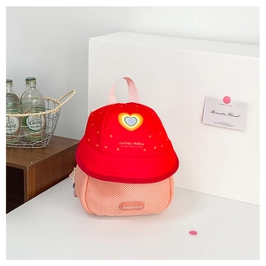 Close-up of cute fruit-style kids backpack with red heart patterns and pink mesh pockets