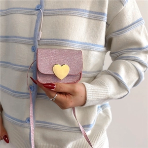 Vue détaillée du mini sac à paillettes rose avec fermoir cœur doré pour enfant