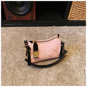 Detail der rosa gesteppten Handtasche mit schwarzen Kontrastkanten und goldener Schnalle