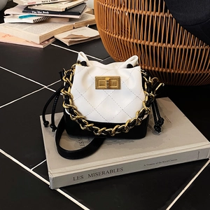 Détail du mini sac seau bicolore avec cuir matelassé et poignée en chaîne dorée