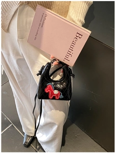 Dettaglio mini borsa nera trapuntata con ricamo pony e trama in pelle lucida