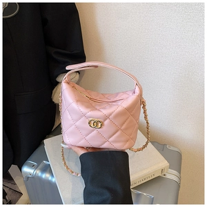 Détail du sac à main matelassé rose avec bandoulière chaîne dorée et logo en métal