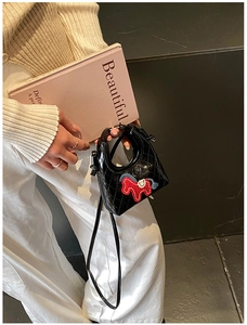Dettaglio della mini borsa trapuntata nera con toppa a forma di cavallo rosso