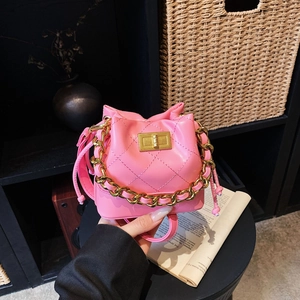 Détail du mini sac seau matelassé rose avec poignée en chaîne dorée et fermoir pivotant