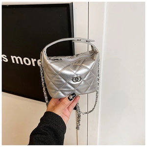 Détail d'un sac à main argenté matelassé avec finition métallique et bandoulière
