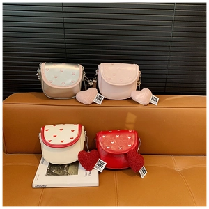 Détails de quatre mini sacs bandoulière avec broderie cœur et breloques en peluche