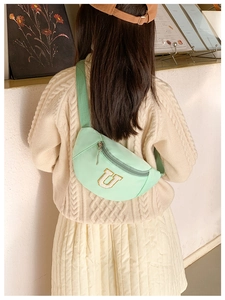 Détail du sac banane enfant vert menthe avec patch U varsity et sangle en nylon