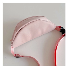 Gros plan sur le sac de poitrine rose pour enfant avec sangle réglable et boucle noire