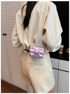 Detail of lavender metallic crossbody mini bag with bow accent and gold chain strap