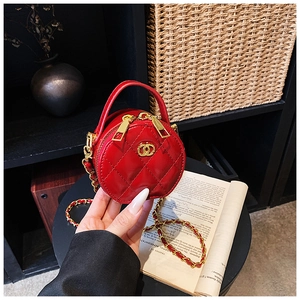 Detail der roten gesteppten runden Kindertasche mit Goldkette und Metallemblem