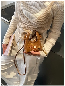 Dettaglio della mini borsa a tracolla trapuntata marrone con ricamo di un piccolo cavallo