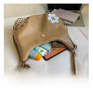 Interior view of brown faux leather hobo bag showing spacious checkered fabric lining