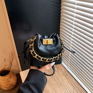 Détail du mini sac seau matelassé noir avec chaîne dorée et fermoir pivotant chic