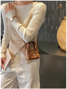 Dettaglio di una mini borsa a tracolla marrone con ricamo pony e texture in pelle liscia