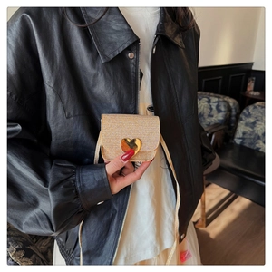 Détail du mini sac bandoulière doré champagne avec fermoir coeur métallique sur un mannequin