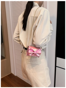 Pink iridescent crossbody bag with diamond stitching and a large metallic bow decoration