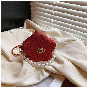 Macro view of a star-shaped red glitter mini bag with pearl handle and metal logo