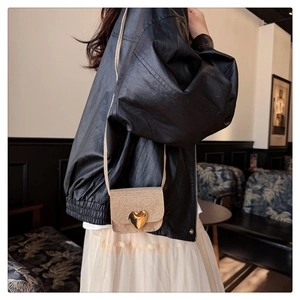 Détail d'un mini sac doré à paillettes pour fille avec fermoir métallique en forme de cœur