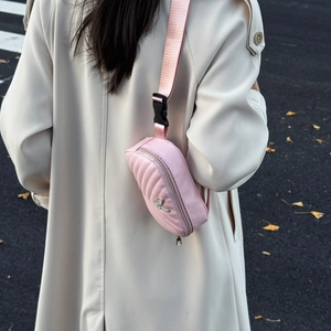 Pink quilted crossbody waist bag for kids featuring a metal butterfly badge accent