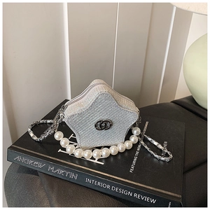 Detail of silver star-shaped mini bag with rhinestones, pearl handle and chain strap