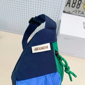 Détail du sac bandoulière enfant en nylon ripstop avec empiècements vert et bleu