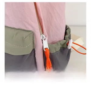 Macro shot of smooth resin zipper and durable nylon fabric in pink and olive green