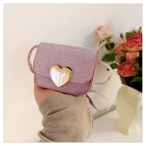 Détail d'un mini sac rose à paillettes avec fermoir cœur doré et bandoulière fine