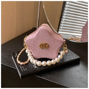 Detailed view of a star-shaped pink glitter kids handbag with pearl handle and chain strap