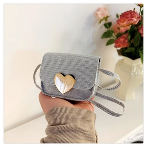 Gros plan du mini sac à paillettes argentées avec fermoir cœur doré et bandoulière