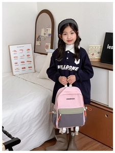 Pink and olive green color-block backpack with large capacity shown on a young girl model