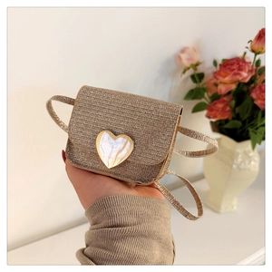 Gros plan du mini sac doré en strass avec un fermoir en métal en forme de cœur et chaîne